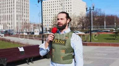 中弹，男电视记者穿着防弹衣在<strong>摩天</strong>大楼前对着麦克风说话
